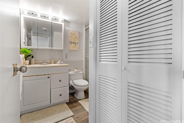 bathroom with vanity, wood-type flooring, and toilet