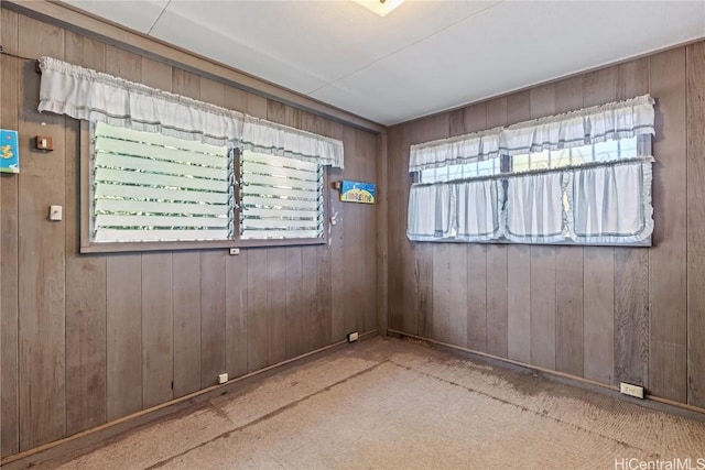 unfurnished room featuring wooden walls