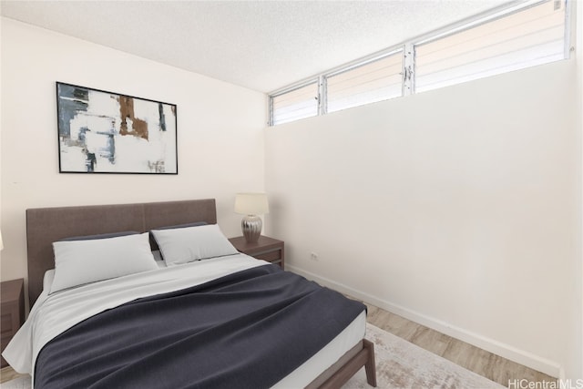 bedroom featuring hardwood / wood-style floors and a textured ceiling