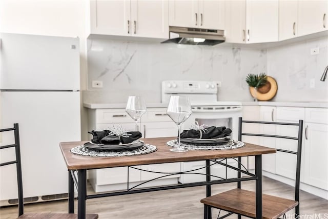 kitchen with white cabinetry, white appliances, light hardwood / wood-style flooring, and backsplash