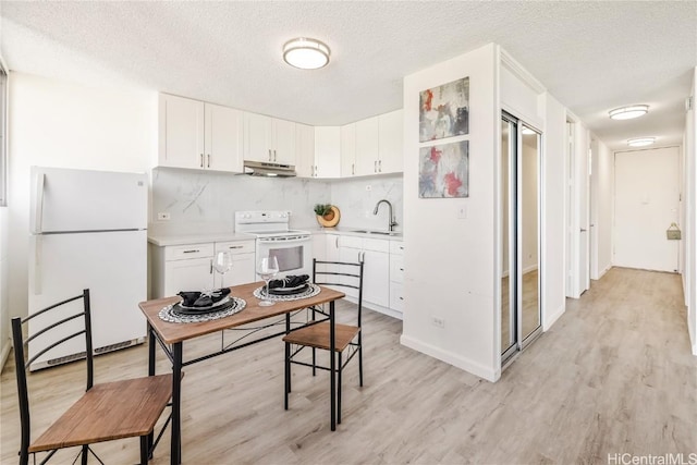 kitchen with white appliances, sink, light hardwood / wood-style flooring, and white cabinets