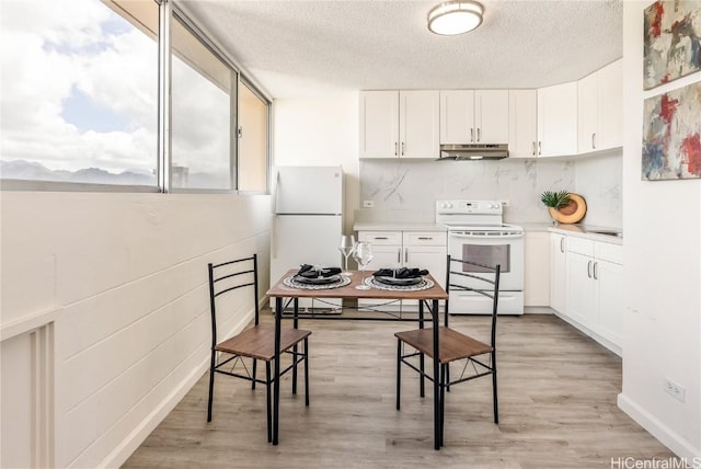 kitchen with white cabinets, white appliances, and light hardwood / wood-style flooring