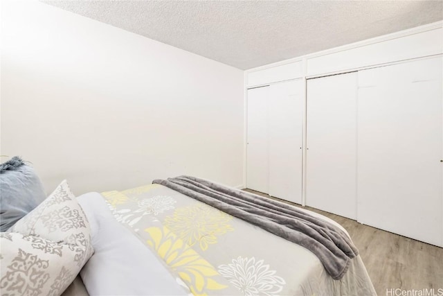 bedroom featuring light hardwood / wood-style flooring, a closet, and a textured ceiling