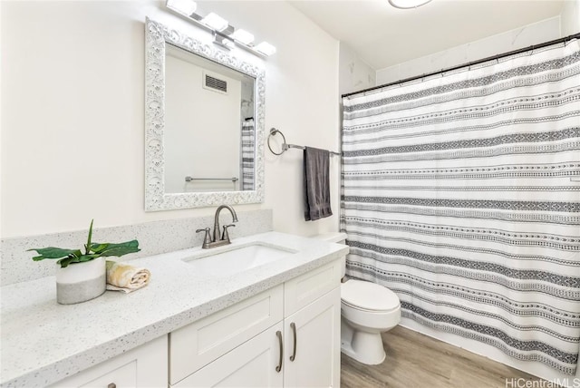 bathroom with vanity, hardwood / wood-style floors, and toilet