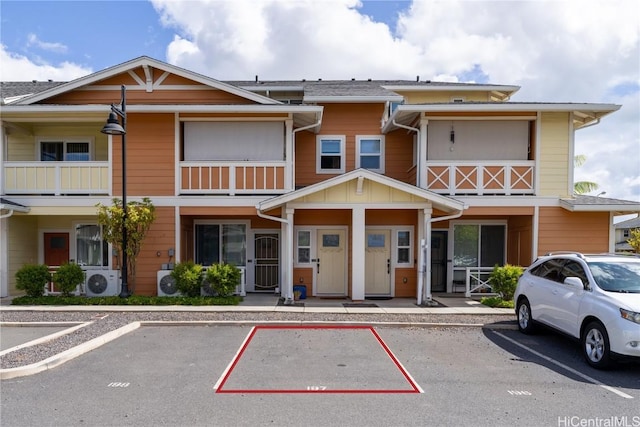 view of front facade with uncovered parking and ac unit