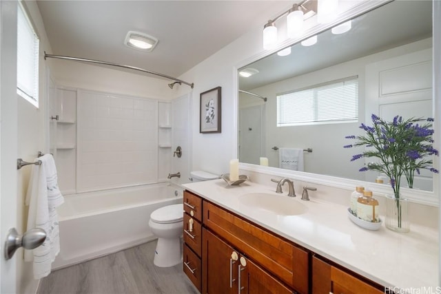 bathroom with toilet, shower / washtub combination, wood finished floors, and vanity