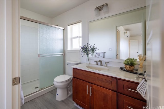 full bathroom with toilet, wood finished floors, a shower stall, and vanity