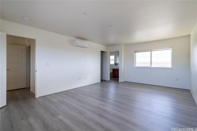 spare room featuring a wall unit AC and light wood-style flooring