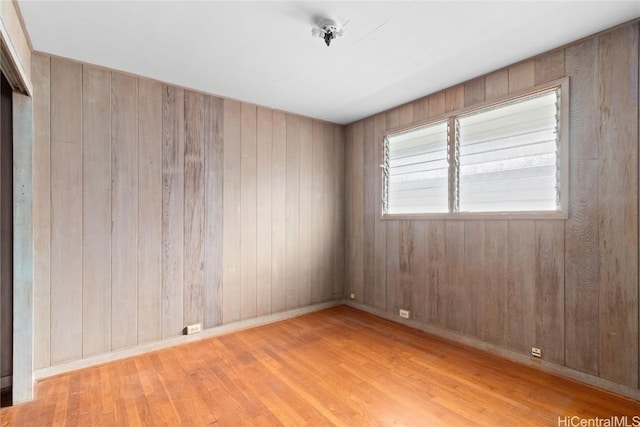 spare room with wooden walls and light hardwood / wood-style floors