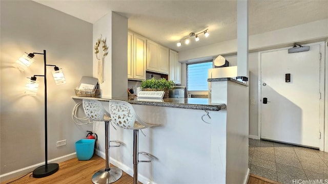 kitchen with white cabinetry, kitchen peninsula, and light hardwood / wood-style floors