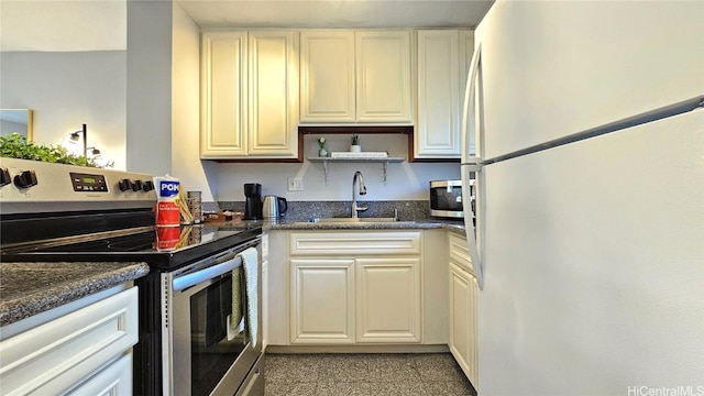 kitchen with appliances with stainless steel finishes, sink, and dark stone countertops