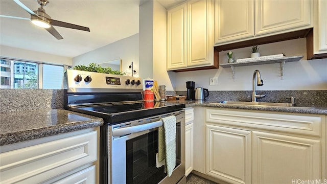 kitchen featuring lofted ceiling, sink, stainless steel range with electric cooktop, dark stone counters, and ceiling fan