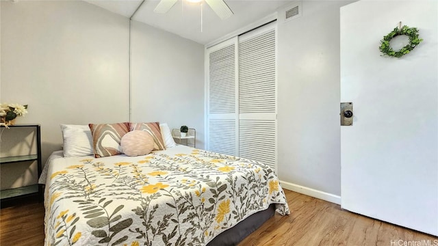 bedroom with hardwood / wood-style flooring, ceiling fan, and a closet