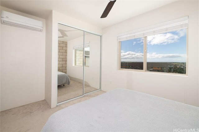 bedroom with multiple windows, light carpet, a closet, and a wall mounted AC