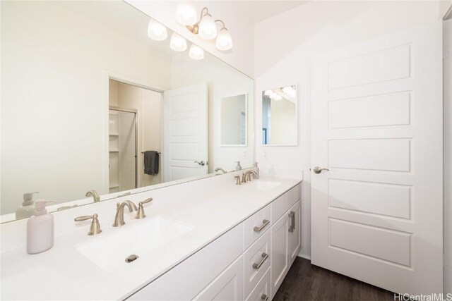 bathroom featuring hardwood / wood-style flooring, vanity, and a shower