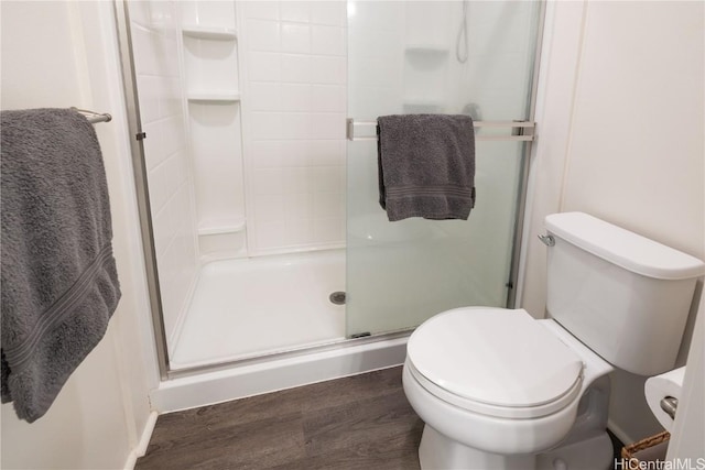 bathroom with walk in shower, toilet, and hardwood / wood-style flooring