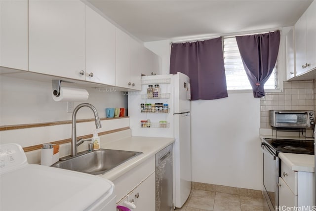 kitchen with tasteful backsplash, appliances with stainless steel finishes, washer / clothes dryer, and white cabinets