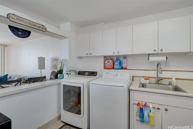 washroom featuring sink, cabinets, and independent washer and dryer