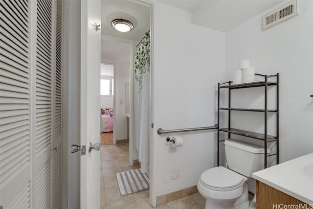 bathroom with vanity, toilet, and tile patterned flooring