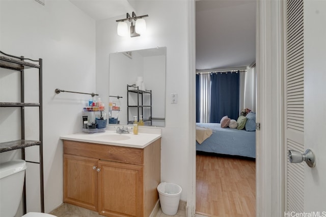 bathroom with hardwood / wood-style flooring, vanity, and toilet