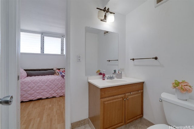 bathroom with vanity, toilet, and hardwood / wood-style floors