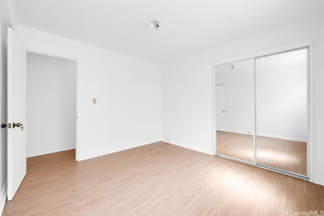 unfurnished bedroom featuring a closet and light hardwood / wood-style flooring