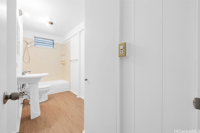 bathroom with toilet, wood-type flooring, and bathtub / shower combination