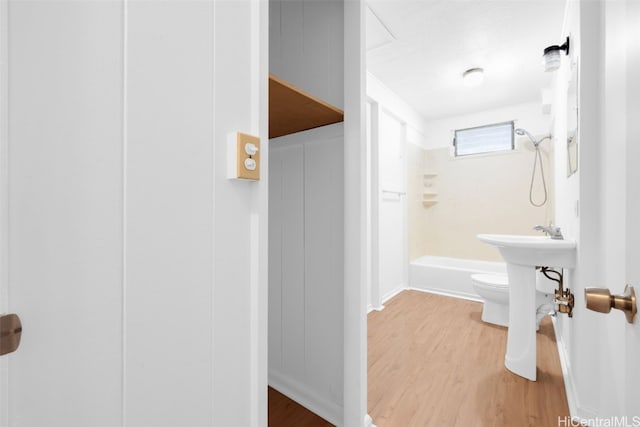 bathroom featuring shower / tub combination, hardwood / wood-style floors, and toilet