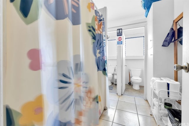 bathroom featuring a shower with curtain, tile patterned floors, and toilet