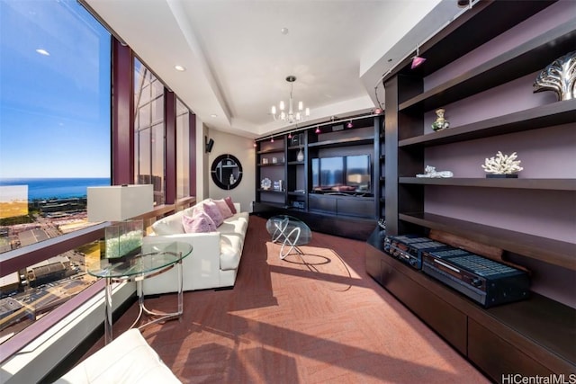 living room featuring a water view, a chandelier, and a wall of windows