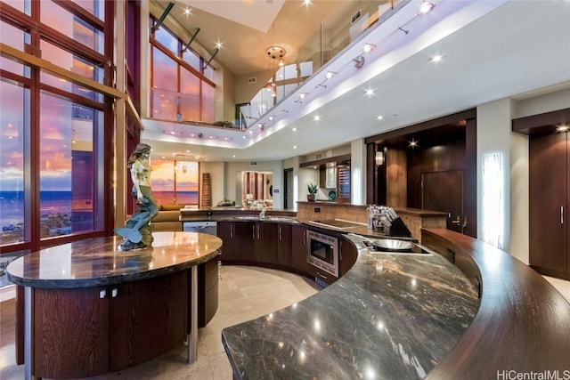 bar featuring sink, black electric stovetop, wall oven, and a towering ceiling