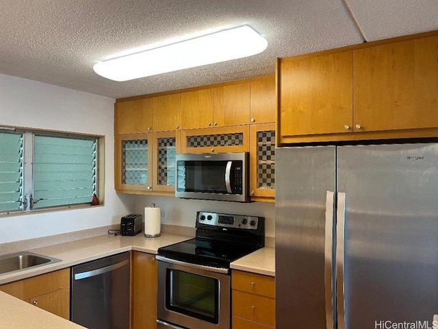 kitchen featuring appliances with stainless steel finishes, sink, and a textured ceiling