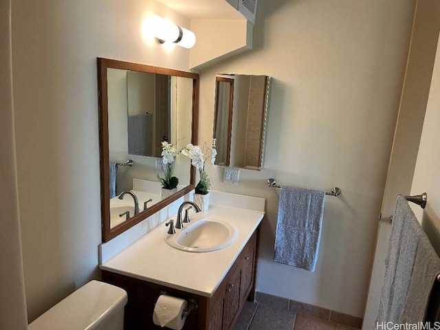 bathroom featuring vanity, tile patterned flooring, and toilet