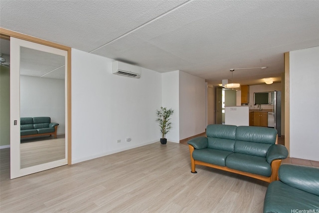 1717 Ala Wai Blvd Unit 505, Honolulu, HI 96815 - living room featuring an AC wall unit, light wood-type flooring, and a textured ceiling
