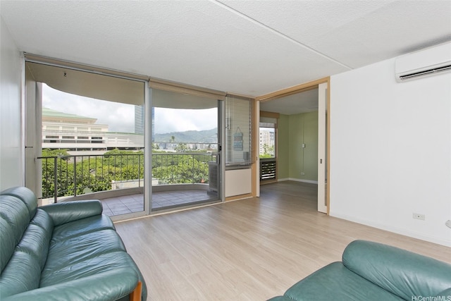 1717 Ala Wai Blvd Unit 505, Honolulu, HI 96815 - living room with a wall unit AC, a wall of windows, wood finished floors, and a textured ceiling