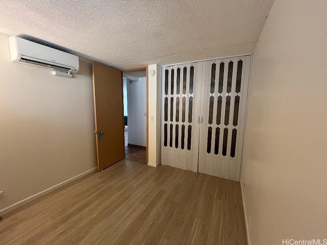1717 Ala Wai Blvd Unit 505, Honolulu, HI 96815 - spare room featuring a wall mounted AC, wood finished floors, and a textured ceiling