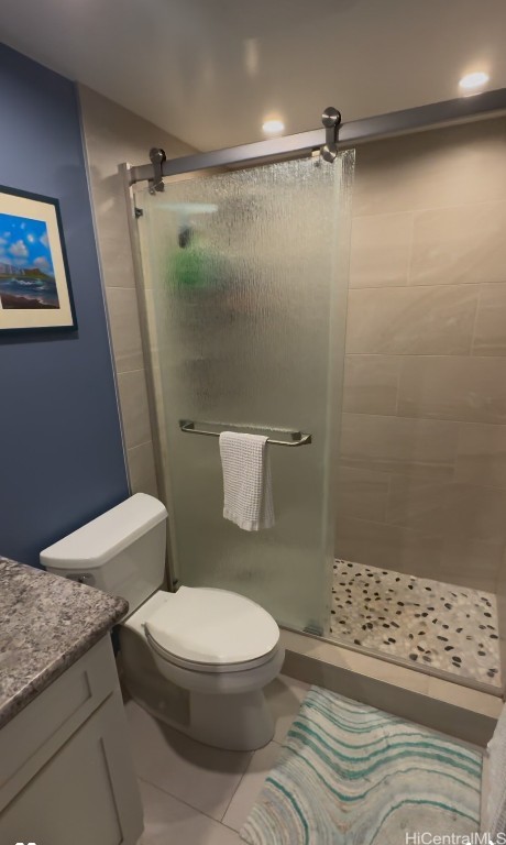 bathroom with walk in shower, vanity, toilet, and tile patterned flooring