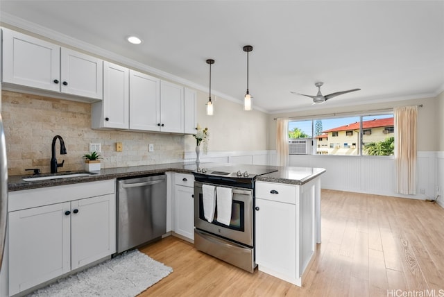 kitchen featuring stainless steel appliances, white cabinets, a sink, and a peninsula