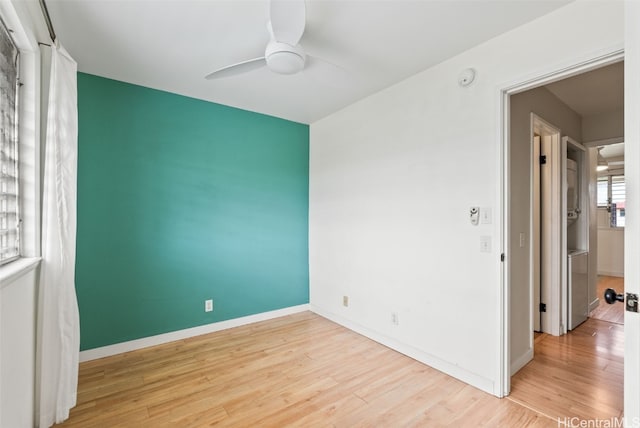 unfurnished room featuring baseboards, a ceiling fan, and wood finished floors