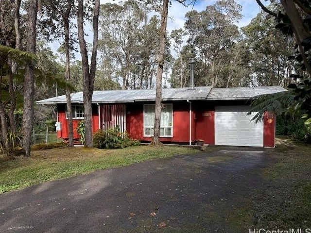 ranch-style home with driveway, an attached garage, and a front yard