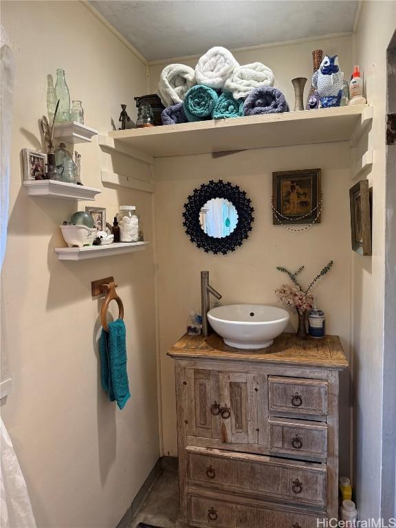 bathroom with crown molding, vanity, and baseboards