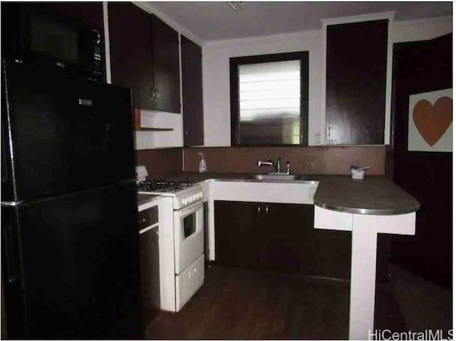 kitchen featuring black fridge, sink, white gas stove, and dark brown cabinets