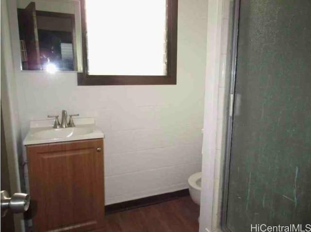 bathroom with vanity, hardwood / wood-style flooring, toilet, and walk in shower