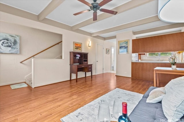 living room featuring beamed ceiling, ceiling fan, sink, and light hardwood / wood-style floors