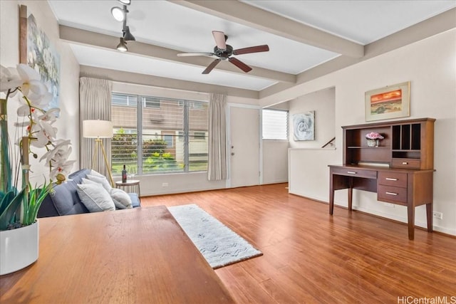 office area featuring beamed ceiling, wood-type flooring, and ceiling fan