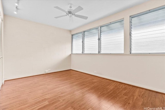 spare room featuring light hardwood / wood-style flooring, rail lighting, and ceiling fan