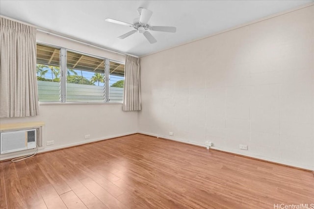 spare room featuring an AC wall unit, ceiling fan, and light hardwood / wood-style flooring