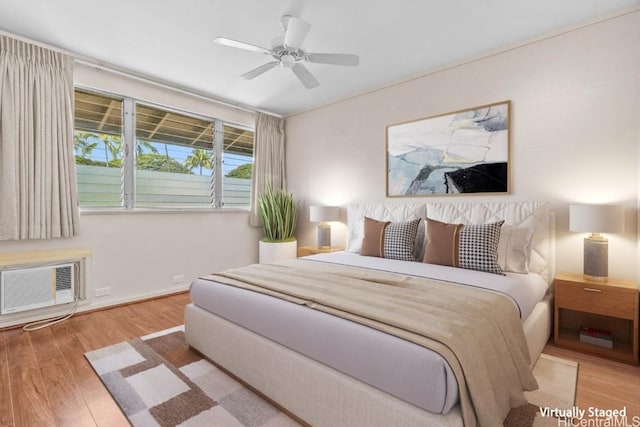 bedroom featuring a wall unit AC, light hardwood / wood-style floors, and ceiling fan