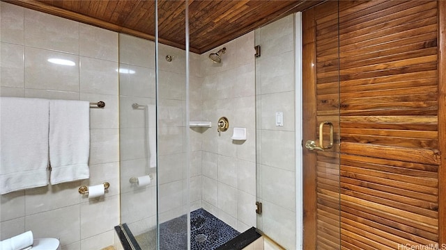 bathroom with wood ceiling, toilet, and a shower with door