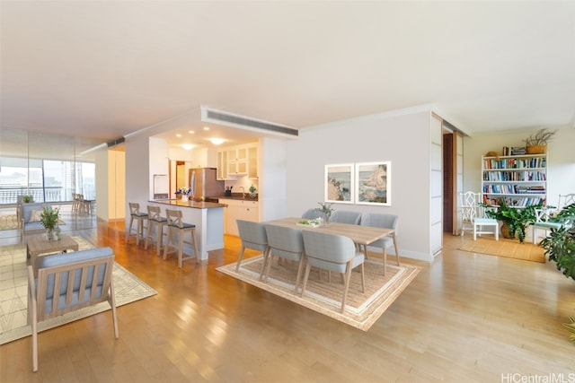 dining room featuring crown molding and light hardwood / wood-style flooring